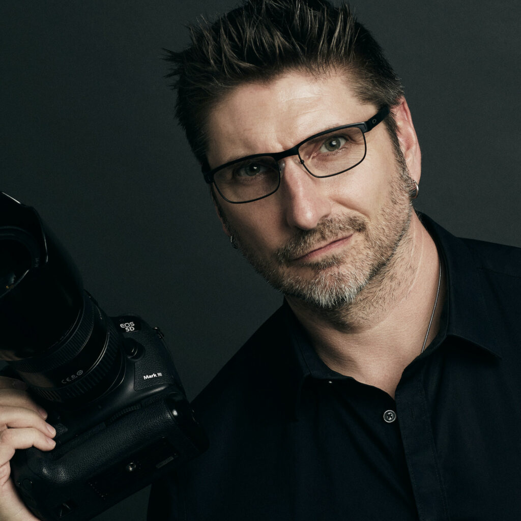 Portrait of photographer Rich Cirminello holding a camera
